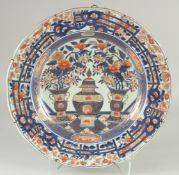 A FINE 18TH CENTURY JAPANESE IMARI PORCELAIN CHARGER, painted with a central lidded jar with vases