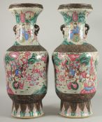 A LARGE PAIR OF CHINESE FAMILLE ROSE PORCELAIN VASES, with moulded twin handles, each painted with a