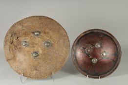 TWO INDIAN SHIELDS, (af), 46cm wide and 34.5cm diameter, (2).