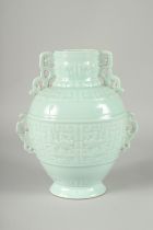 A CHINESE CARVED CELADON GLAZE PORCELAIN VASE, with four pierced handles and carved bands of