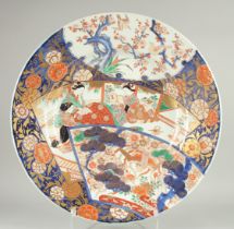 A LARGE 19TH CENTURY JAPANESE IMARI PORCELAIN CHARGER, enamel painted with a scene of seated