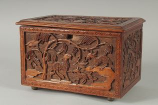 A GOOD CHINESE CARVED WOOD TEA CHEST, carved with various animals including fish, goats, and