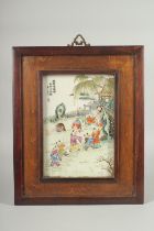 A CHINESE REPUBLIC FAMILLE ROSE PORCELAIN PLAQUE, inset within a hardwood frame, panel depicting