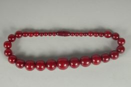 A CHERRY-COLOUR BEADED NECKLACE.