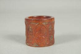 A CHINESE CARVED AND STAINED BONE THUMB RING.