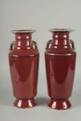 A PAIR OF CHINESE SANG DE BOEUF TWIN HANDLE VASES, (one with minor rim repair), 34cm high (