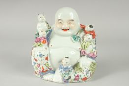 A CHINESE FAMILLE ROSE PORCELAIN BUDDHA, with five children upon him, 19.5cm high.