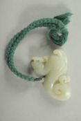 AN EARLY 20TH CENTURY CHINESE CARVED JADE PENDANT OF A LION DOG, 6cm wide.