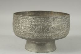 AN INDIAN ENGRAVED TINNED COPPER FOOTED BOWL, 19cm diameter.