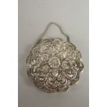 A SMALL EMBOSSED SILVER MIRROR, 10cm wide.