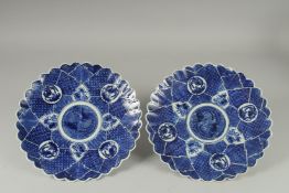 A PAIR OF JAPANESE BLUE AND WHITE PORCELAIN PETAL-FORM PLATES, 31cm wide.