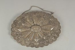 A LARGE EMBOSSED SILVER OVAL MIRROR, 29.5cm x 22cm.