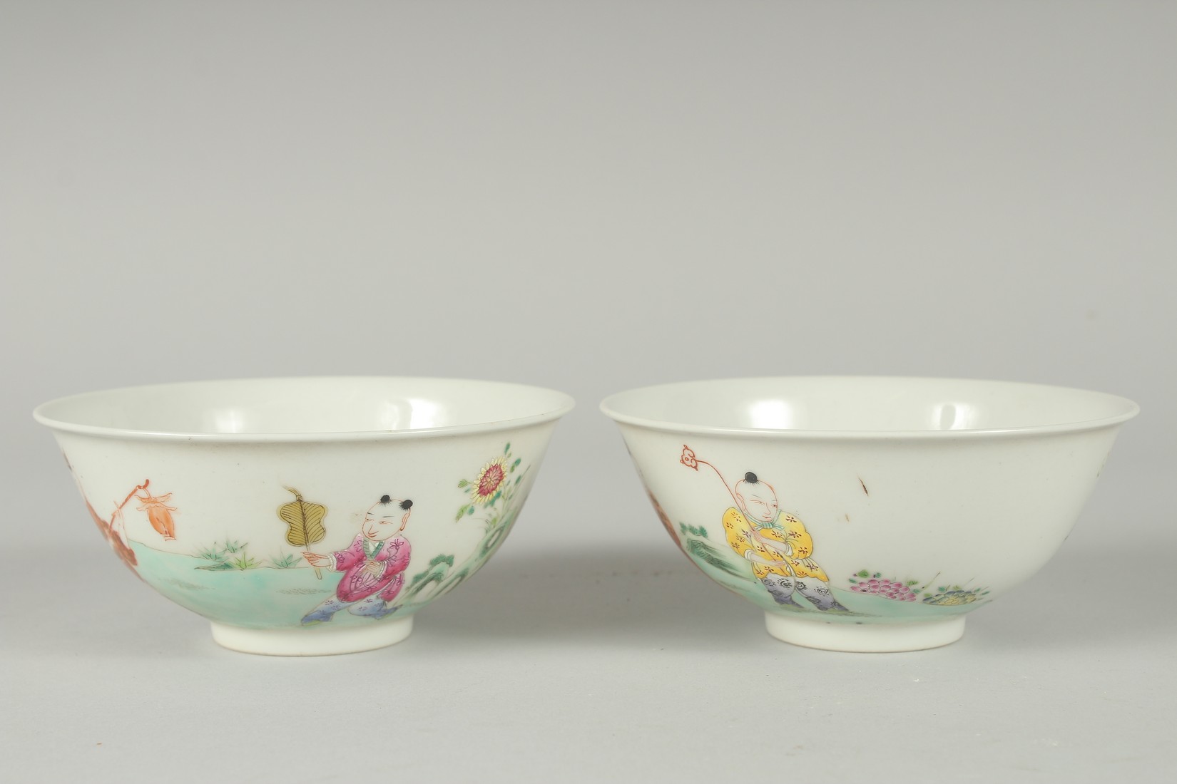 A PAIR OF EARLY 20TH CENTURY FAMILLE ROSE PORCELAIN RICE BOWLS, painted with boys, each with red - Image 4 of 6