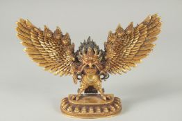 A FINE TIBETAN GILT BRONZE DEITY, with wings outstretched, inscribed to the base, 19cm wide.