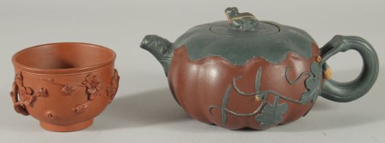 A CHINESE YIXING TEAPOT AND TEA BOWL, the teapot carved with lily and frog finial, impressed mark to