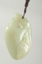 A CHINESE CARVED JADE PEBBLE PENDANT, 8cm x 5cm.