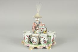 A 19TH CENTURY FAMILLE ROSE PORCELAIN FIGURAL GROUP of a seated vase seller surrounded by six vase-
