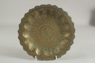 AN ISLAMIC ENGRAVED BRASS DISH, the reverse with inscription, 23.5cm diameter.