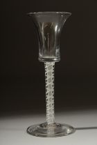 A GEORGIAN WINE GLASS with inverted bell shape bowl and white twist stem. 6ins high.