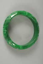 A CARVED JADE BANGLE. 7cm diameter.