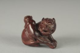 A CARVED WOOD DOG OF FOE NETSUKE, Signed, 1.5ins.