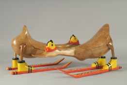A PAIR OF NOVELTY CARVED WOOD SKIING DUCKS. 17ins long.