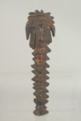 AN EARLY CARVED WOOD IDOL. 10ins long.