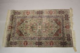 A GOOD SMALL PERSIAN SILK RUG cream ground with all over floral design. 5ft x 3ft 1ins.