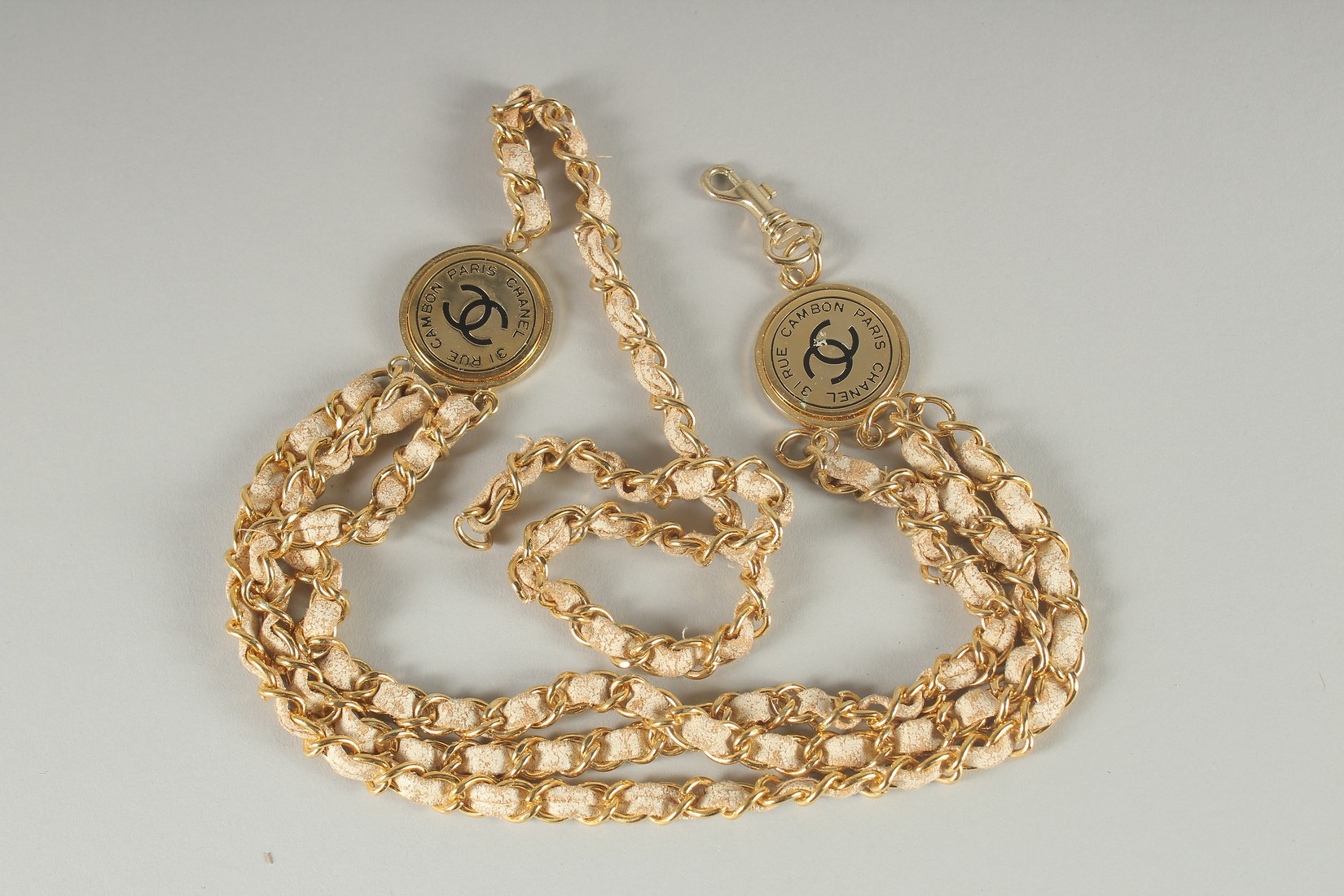 A CHANEL TRIPLE ROW GILT AND LEATHER NECKLACE. 16ins long.