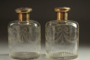 A PAIR OF CUT GLASS SCENT BOTTLES with silver tops. London, 1929.