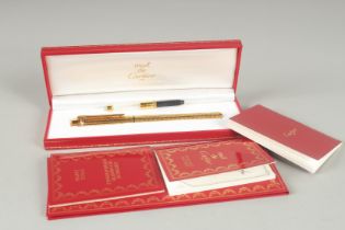 A CARTIER DE MUST GILT FOUNTAIN PEN, 1990, No. 850919 with a .750 gold nib. In a red Cartier box and