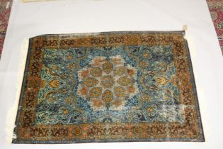 A FINE PERSIAN SILK RUG turquoise ground with stylised motifs and medallions. Signed. 6ft 6ins x 4ft