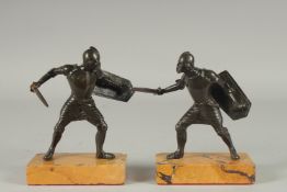 A GOOD PAIR OF 19TH CENTURY BRONZE FIGHTING SOLDIERS carrying a sword an shield, standing on a