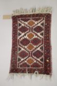 A SMALL PERSIAN MAT red ground with a geometric design. 2ft x 1ft 4ins.