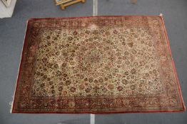 A GOOD LARGE PERSIAN SILK CARPET cream ground within a red ground border, decorated with floral