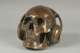 A BRONZE SKULL with headphones. 6ins high.