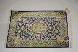 A GOOD SMALL PERSIAN SILK RUG blue ground with stylised floral decoration, with a similar green