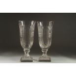 A GOOD PAIR OF CUT GLASS VASES on stepped square bases. 11.5ins high.