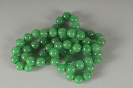 A STRING OF SIXTY SIX JADE BEADS. 32cm long.