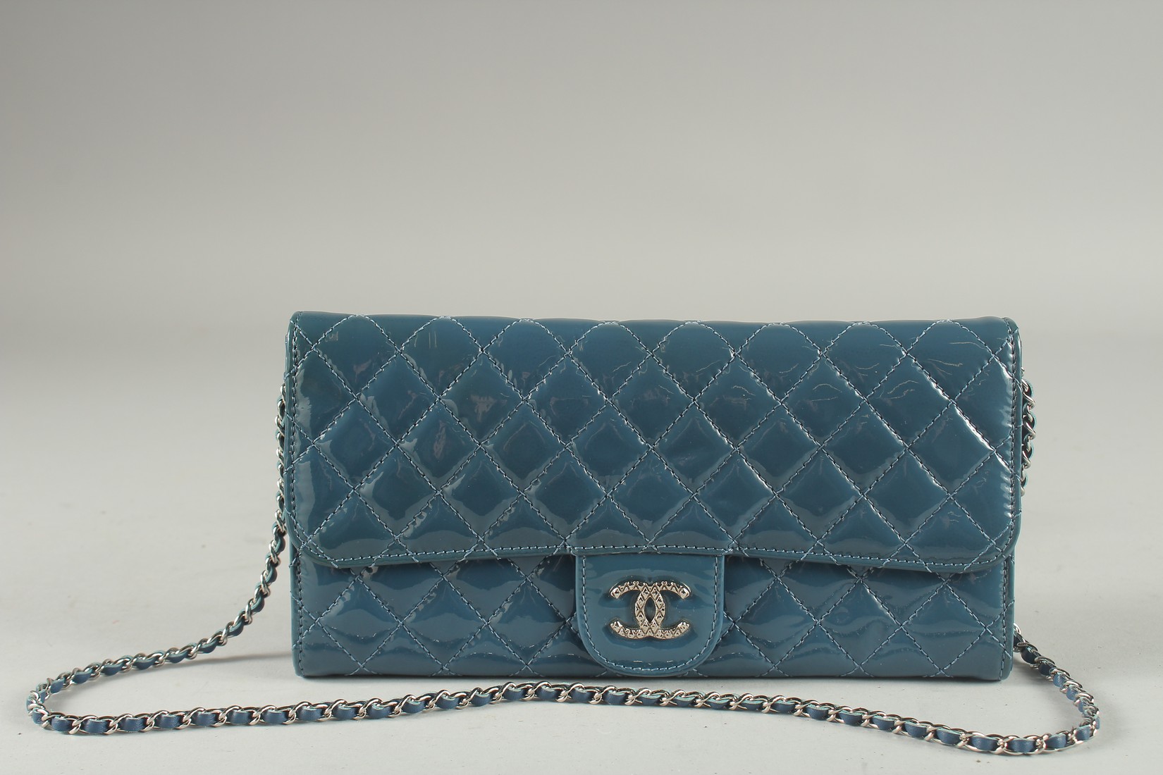A VERY GOOD CHANEL BLUE PATENT LEATHER HAND BAG with double C medallion. 9.5ins long, 4.75ins deep