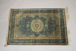 A GOOD SMALL PERSIAN SILK RUG turquoise ground with fine floral decoration. Signed. 4ft 10ins x