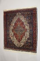 A PERSIAN WOOL CARPET cream, red and blue ground with all over stylised decoration. 4ft 9ins x 4ft