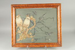 A FRAMED NEEDLEWORK PICTURE OF TWO OWLS on a branch. 16ins x 19ins.