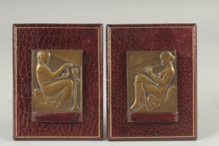 A PAIR OF ART NOUVEAU CAST BRONZE RELIEFS on leather strut frames. 2.75ins x 2.25ins.