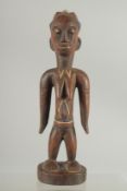 A STANDING TRIBAL FIGURE , traces of pigment. 10ins high.