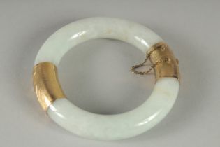 A 9CT GOLD MOUNTED JADE BANGLE. 3ins diameter.