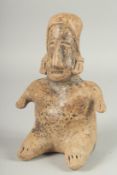 A RARE SOUTH AMERICAN POTTERY SEATED FEMALE FIGURE. 9.5ins high.