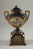 A SMALL VIENNA RICH BLUE GROUND TWO HANDLED URN AND COVER with a panel of a young lady with a cupid.