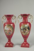 A PAIR OF SEVRES DESIGN RED GROUND PORCELAIN VASES AND COVERS decorated with reverse scenes of