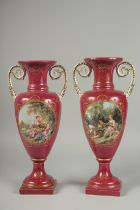 A PAIR OF SEVRES DESIGN RED GROUND PORCELAIN VASES AND COVERS decorated with reverse scenes of